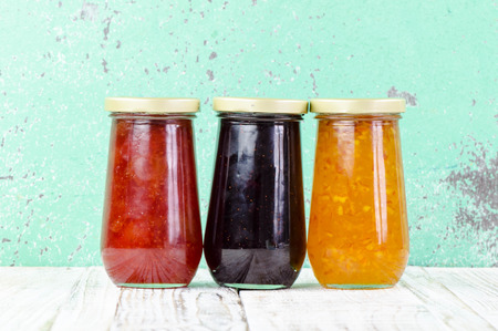 Homemade jars of fruits jam on rustic wooden backgroundの写真素材
