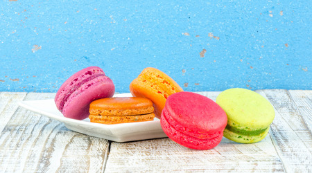 Colorful macarons on vintage pastel background. Macaron or Macaroon sweet meringue-based confection.の写真素材