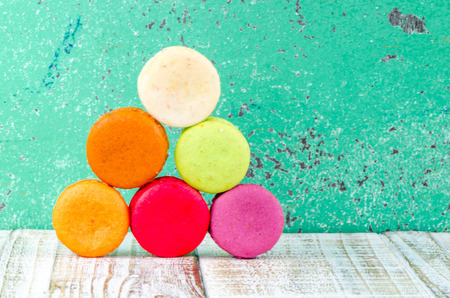 Colorful macarons on vintage pastel background. Macaron or Macaroon sweet meringue-based confection.の写真素材