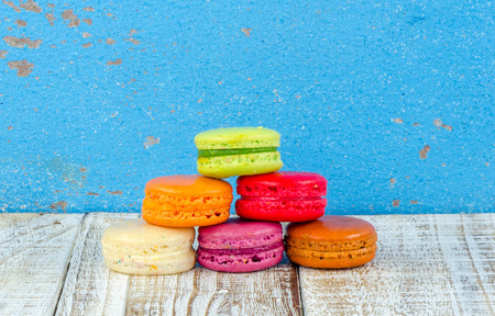 Colorful macarons on vintage pastel background. Macaron or Macaroon sweet meringue-based confection.の写真素材