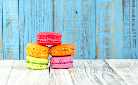Colorful macarons on vintage pastel background. Macaron or Macaroon sweet meringue-based confection.の写真素材
