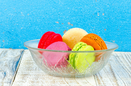 Colorful macarons on vintage pastel background. Macaron or Macaroon sweet meringue-based confection.の写真素材