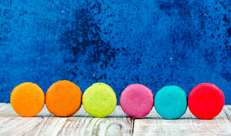 Colorful macarons on vintage pastel background. Macaron or Macaroon sweet meringue-based confection.