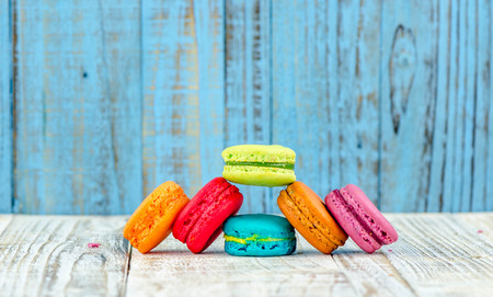 Colorful macarons on vintage pastel background. Macaron or Macaroon sweet meringue-based confection.の写真素材