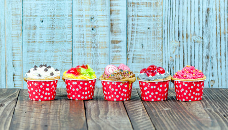 Colorful cupcakes on a wooden backgroundの写真素材
