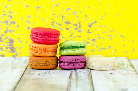 Colorful macarons on vintage pastel background. Macaron or Macaroon sweet meringue-based confection.の写真素材