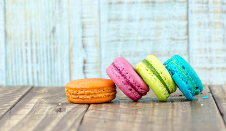 Colorful macarons on vintage pastel background. Macaron or Macaroon sweet meringue-based confection.の写真素材