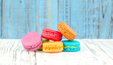 Colorful macarons on vintage pastel background. Macaron or Macaroon sweet meringue-based confection.の写真素材