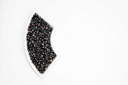 Black beans in a cup on a white background.