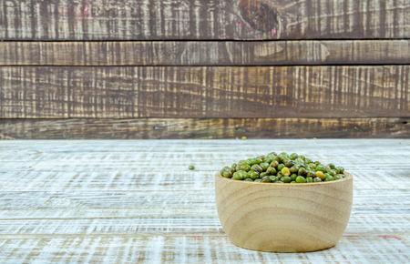 Green beans in a cup on a wooden background.の写真素材