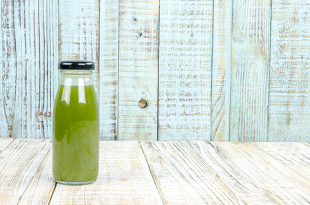 Kiwi juice bottle on vintage wooden backgroundの写真素材