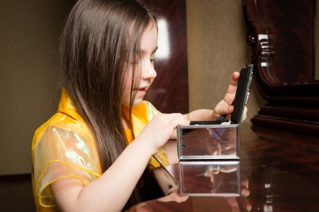 Girl in a yellow dress with a yellow bow  Looks in a casketの写真素材