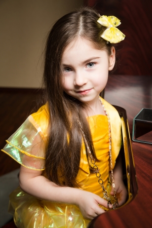 Girl in a yellow dress with a yellow bow の写真素材