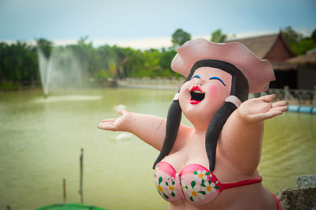 Statue of a woman who throws up his hands at the lake with a fountainの写真素材