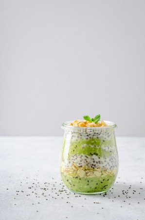 One glass jar with chia pudding with kiwi and granola. Horizontal image, copy space, front viewの写真素材