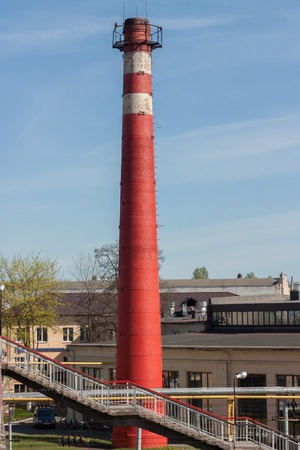 Single red brick industrial chimney standing  alongの写真素材
