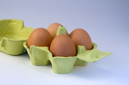 four eggs in yellow basket, isolated