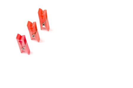 three red clothepegs isolated on white backgroundの写真素材