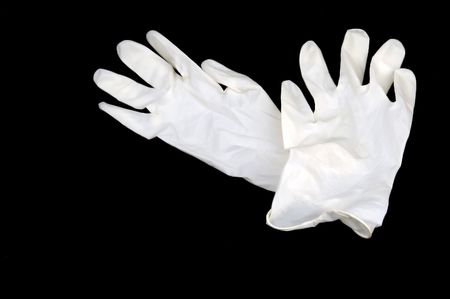 white medical gloves isolated on black backgroundの写真素材