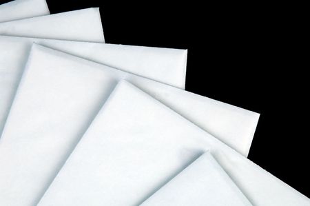 stack of white envelopes isolated on black background