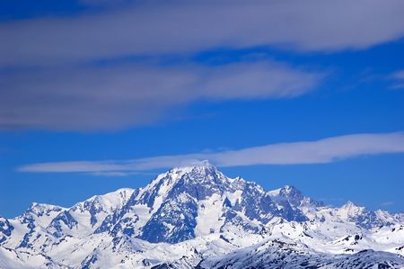 snowed mountainrange surrounded by  cloudsの写真素材