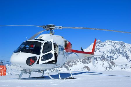 red and white rescue helicopter parked in the mountinsの写真素材