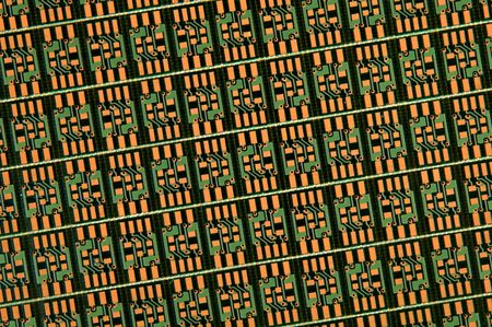 a close up of green and orange circuit plate pattern