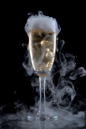 Glass of white wine isolated over black background, with a lot of smokeの写真素材