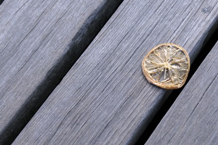 The withered segment of a lemon lies on a wooden flooringの写真素材