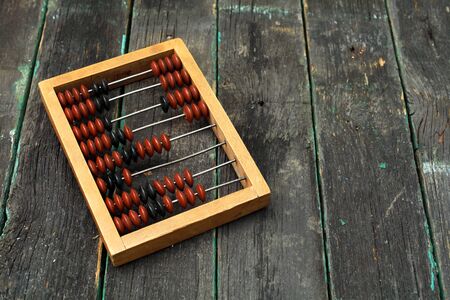 Old wooden abacus on a wooden background with place for your text.