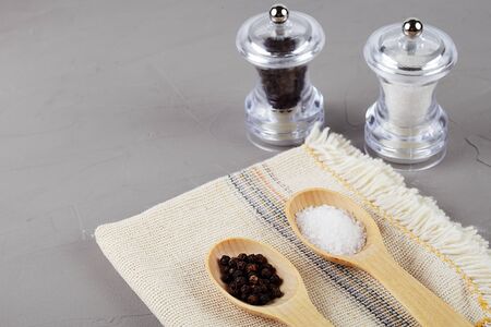 Wooden spoons on a linen napkin with pepper and sea salt, copy spaseの写真素材