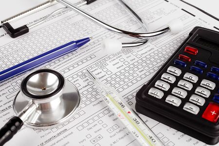 Healthcare costing. Medical phonendoscope, calculator, pen, medical thermometer.