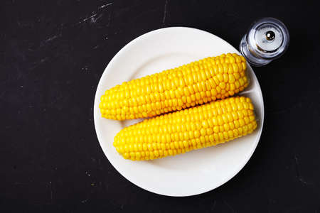 boiled corn, on a white plate, place for your textの写真素材
