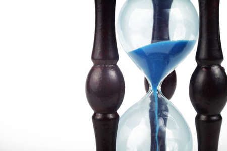 Hourglass with blue sand on a white background, super macro, place for your text, selective focus.