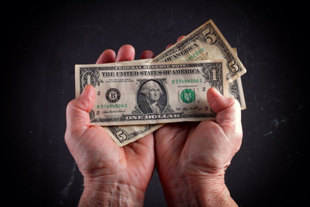 dollars in the hands of an elderly woman, close-up, vignetting.