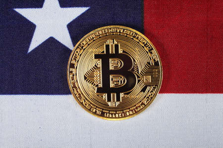 Golden bitcoin on usa flag, closeup, top viewの写真素材