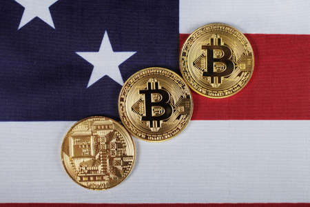 Three bitcoins on the flag of the United States, top view.の写真素材