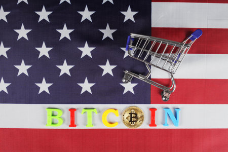 The inscription bitcoin and gold bitcoin on the flag of the United States, next to it is a cart from the supermarket, a place for your textの写真素材