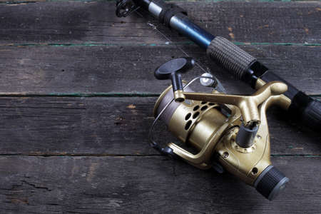 Fishing spinning rod with a reel on a dark background, copy space.の写真素材