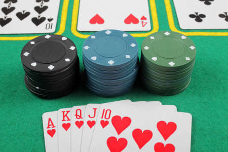 Casino chips and cards with a winning combination of royal flush on the table ,.