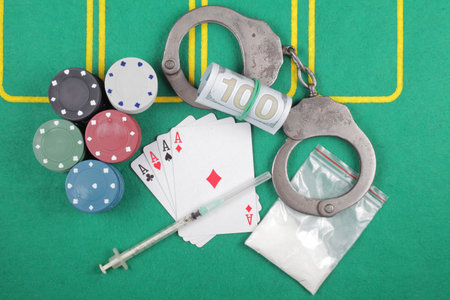 Casino chips winning combination of cards four aces next to police handcuffs, top view.