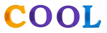 The word cool is lined with multicolored plastic letters isolated on white background.の写真素材