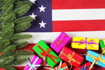 artificial fir branches and gift boxes on american flag, top view