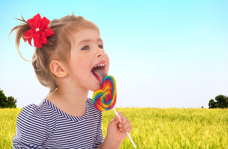 Adorable little girl licks ledinets lollyの写真素材