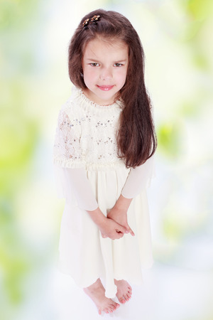 dark-haired girl in a white dress.walk in the field, summer joy,happiness concept,happy childhood,carefree childhood,active lifestyleの写真素材