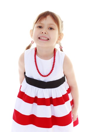 girl in a striped white and red dress with red beads on a white background Summer fun, the concept of happiness and family wellbeing の写真素材