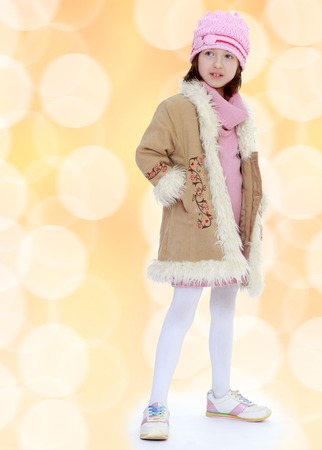 Fashionable girl in a winter coat and knit capの写真素材