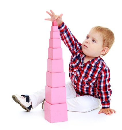 Little boy puts cubes.Early years learning a happy childhood concept.Isolated on white background.の写真素材