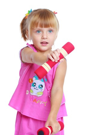 Happy childhood, sports, child development concept.little girl with dumbbells.Isolated on white background.の写真素材