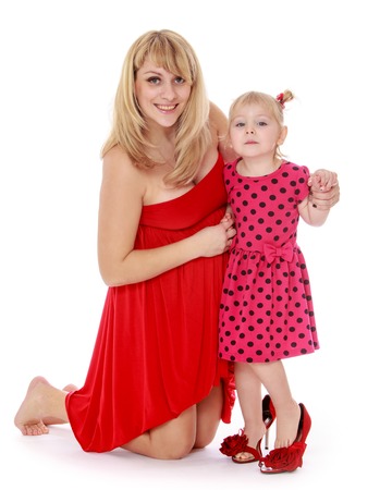Alluring very fashionable mother and daughter in a red dress.Isolated on white background, Lotus Childrens Center.の写真素材